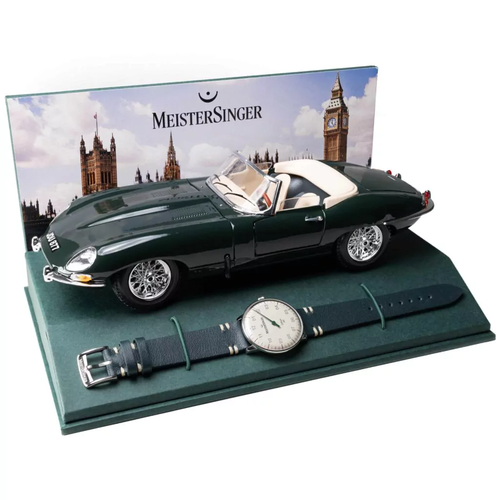 クラシックカーの美学を腕元に──MeisterSinger「Edition Neo J.E」は、ジャガーEタイプのデザインを受け継ぐブリティッシュ・レーシング・グリーンのダイヤルとヴィンテージサドルレザーストラップを備えた自動巻き腕時計。シングルハンドの独自スタイルと世界限定100本の希少性に加え、Bburago製ジャガーEタイプ・ミニチュアカーを含むコレクター必携の特別セット。